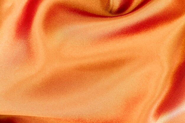 Struttura materiale del tessuto arancio con lo spazio della copia