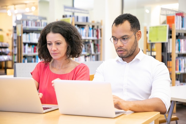 Studente adulto che tradisce durante la prova in biblioteca