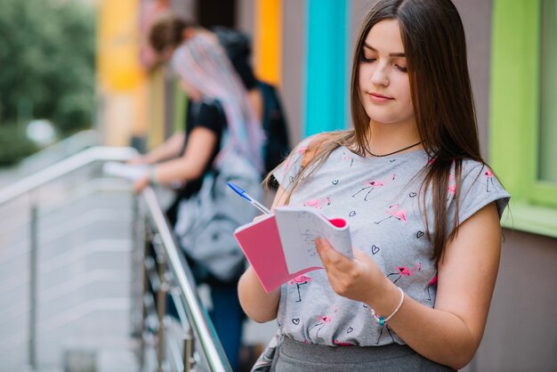 Studente bello con blocchetto per appunti