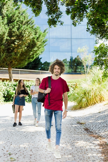 Studente che cammina nel campus con lo zaino