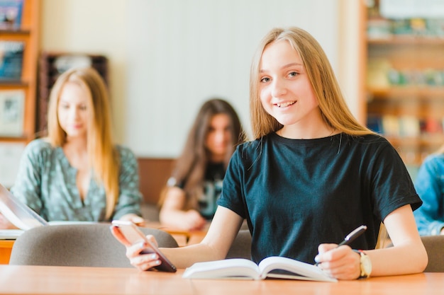 Studente con lo smartphone che guarda l&#39;obbiettivo