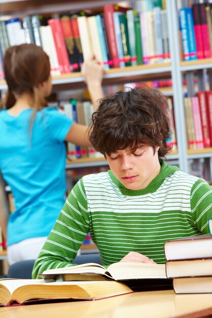 studente concentrato circondato da libri