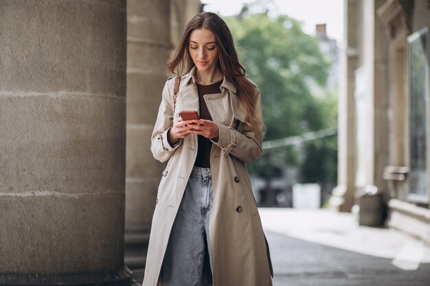 Studente della giovane donna dall'università che parla sul telefono