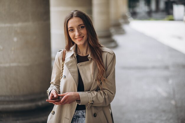 Studente della giovane donna dall'università che parla sul telefono