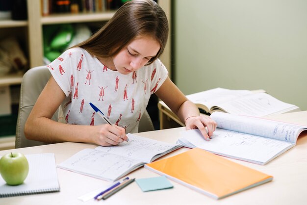 Studente di ragazza premuroso seduto e scrivendo