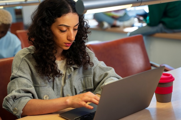 Studente di vista laterale che impara con il computer portatile