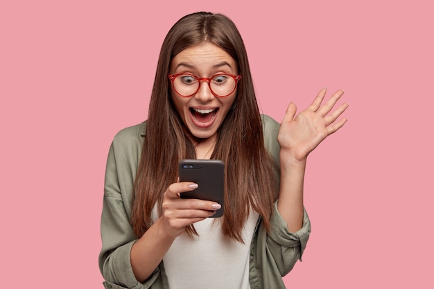 Studente felicissimo in posa contro il muro rosa