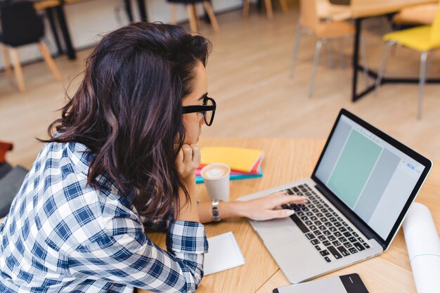 Studente grazioso intelligente a studiare con il computer portatile nella biblioteca dell'università. Attraente giovane donna al lavoro, libero professionista, navigazione in internet, raggiungere il successo, ragazza intelligente e intelligente.