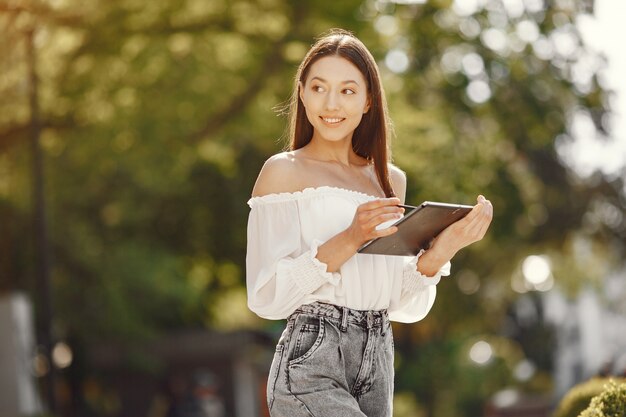 Studente in piedi in una città con un tablet