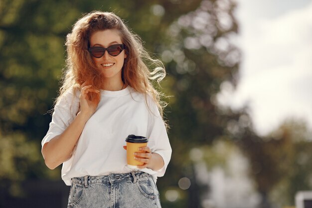 Studente in piedi in una città con una tazza di caffè