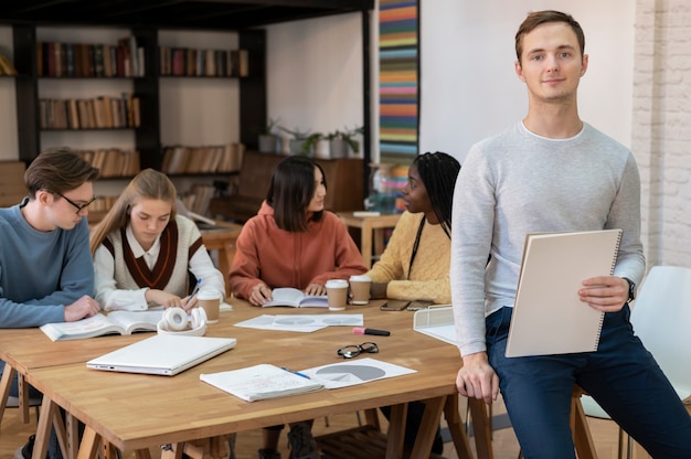 Studente in posa durante una sessione di studio di gruppo con i colleghi