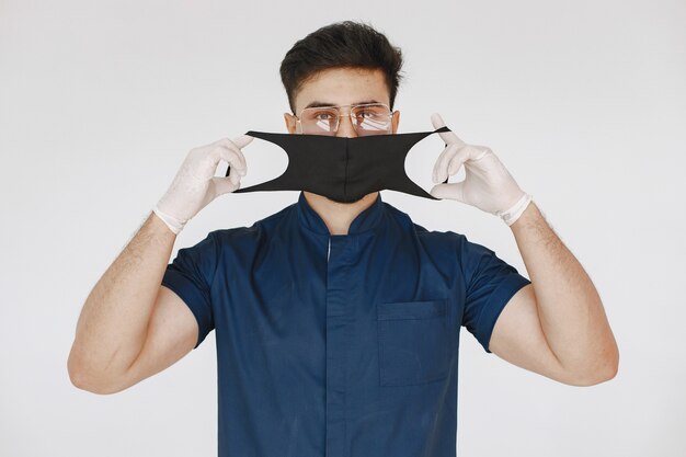 Studente internazionale di medicina. Uomo in uniforme blu. Dottore in maschera.