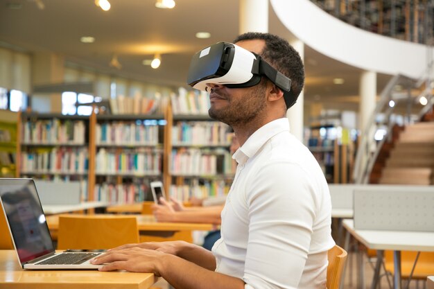 Studente maschio adulto con auricolare VR