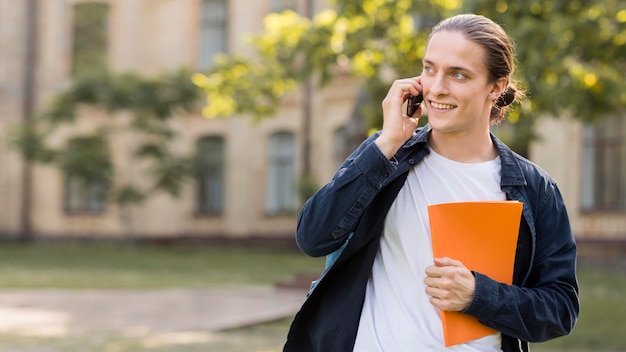 Studente maschio positivo che parla sul telefono