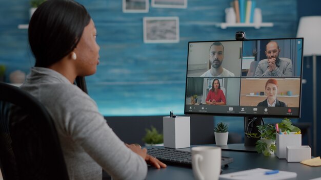 Studente nero che parla con il team dell'università di marketing durante la teleconferenza videochiamata online che spiega il corso virtuale della scuola school