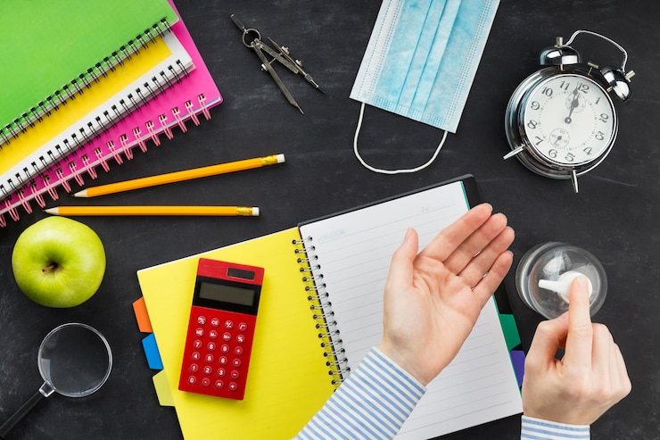 Foto gratuito studente piatto laico utilizzando disinfettante