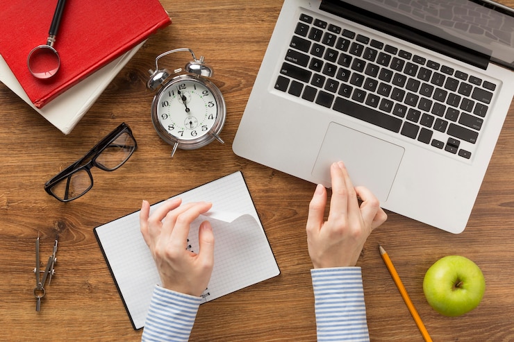 Foto gratuito studente piatto laico utilizzando un computer portatile