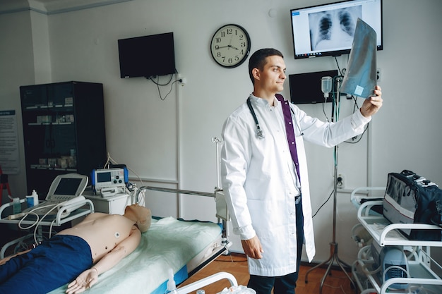 .Studente pratica medicina. Un uomo in camice medico e con uno stetoscopio esegue un esame.