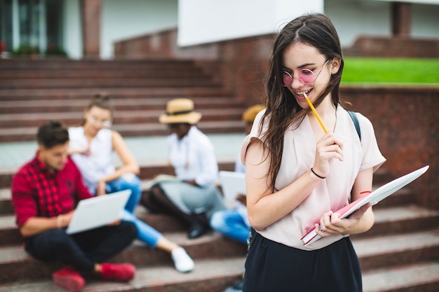 Studente sognante abbastanza in posa con il blocchetto per appunti