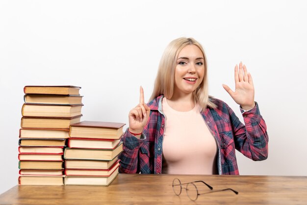 studentessa appena seduta con libri su bianco