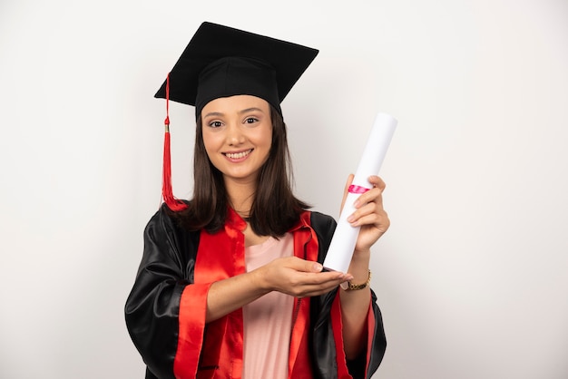 Studentessa che mostra diploma su sfondo bianco.