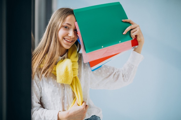 Studentessa che sta con le cartelle variopinte