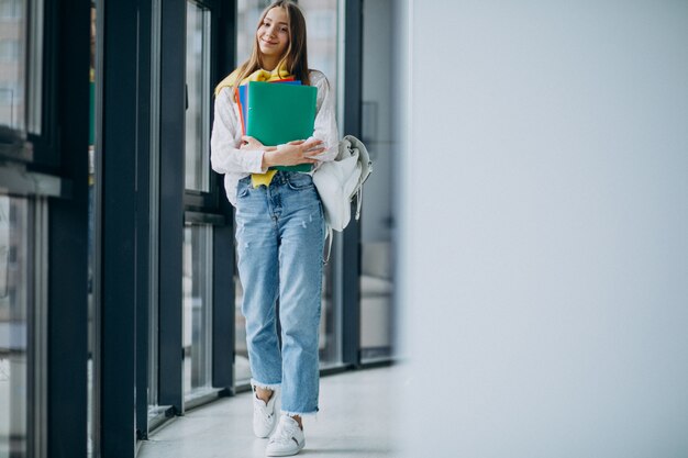 Studentessa che sta con le cartelle variopinte