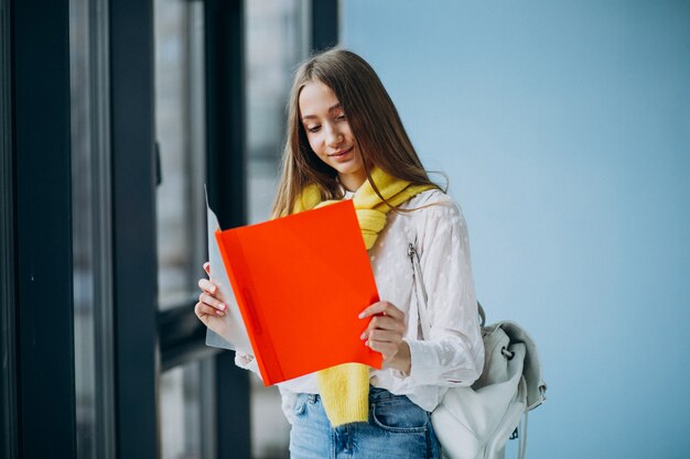 Studentessa che sta con le cartelle variopinte