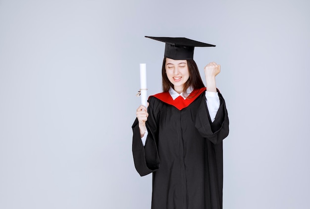 Studentessa con diploma universitario in posa per la telecamera. Foto di alta qualità