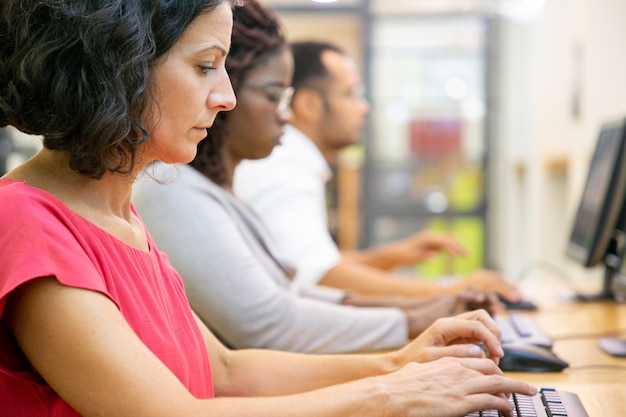 Studentessa di mezza età messa a fuoco che studia nella classe del computer