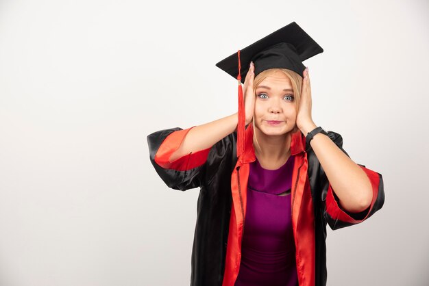 Studentessa in abito che sembra sorpresa su bianco.