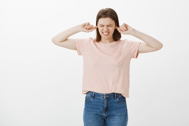 Studentessa infastidita e infastidita chiude le orecchie, non riesce a sentire nulla dal rumore forte, dal suono inquietante