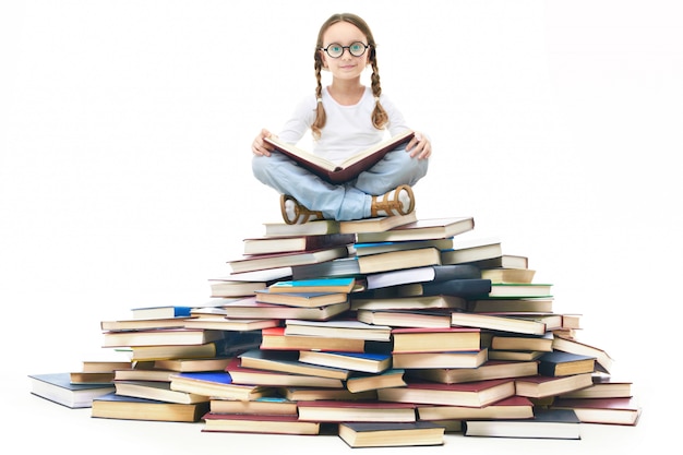Studentessa lettura su una pila di libri