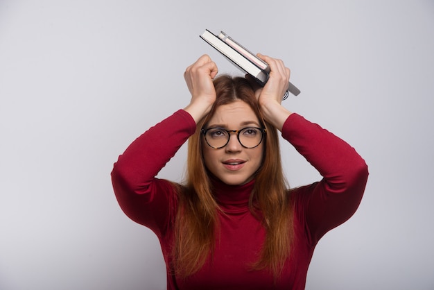 Studentessa nervosa con i libri sopraelevati