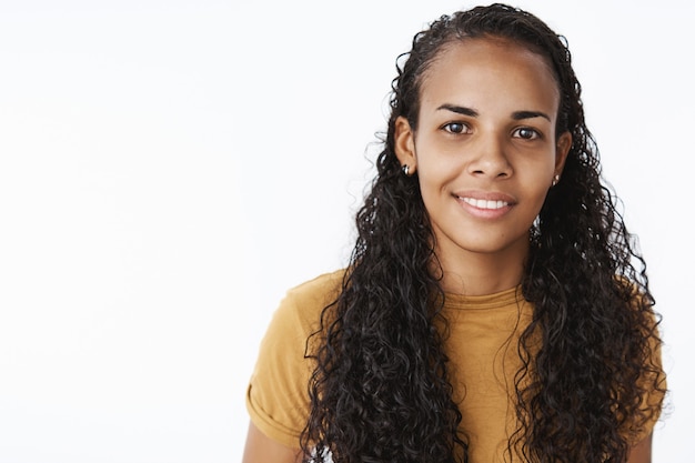 Studentessa piuttosto afroamericana che guarda l'obbiettivo con un sorriso soddisfatto