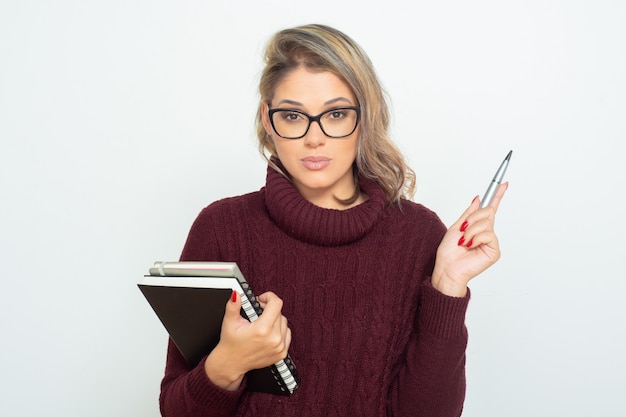 Studentessa seria con libri e penna