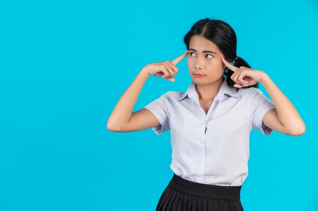 Studentesse asiatiche che eseguono i vari gesti su un blu.