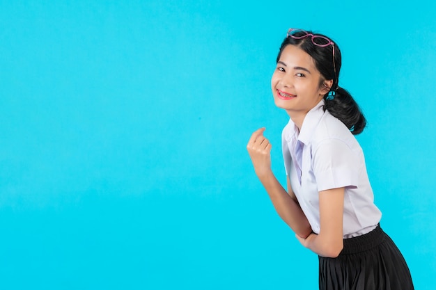 Studentesse asiatiche che posano in varie posizioni su un blu.