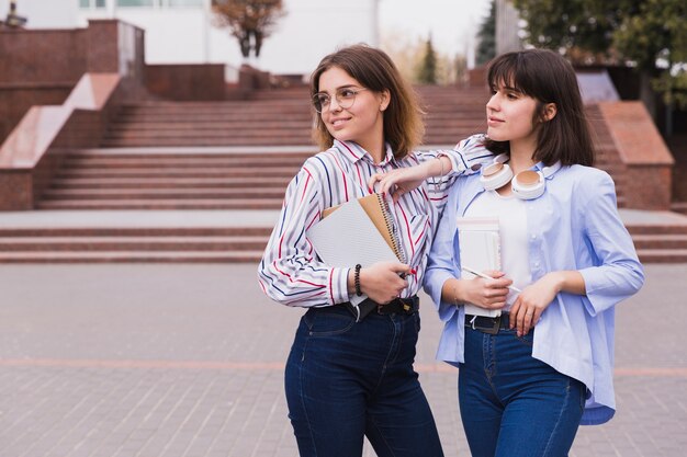 Studenti adolescenti in camicie leggere in piedi con i libri