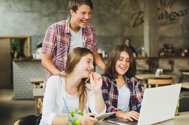 Studenti allegri in posa con il computer portatile