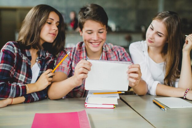 Studenti che osservano blocco note e sorridono