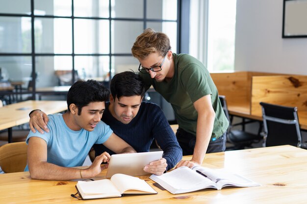 Studenti concentrati che passano in rassegna sul computer e sulla conversazione del ridurre in pani