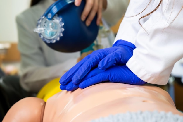 Studenti di medicina che praticano la rianimazione cardiopolmonare di emergenza su una bambola di pratica medica