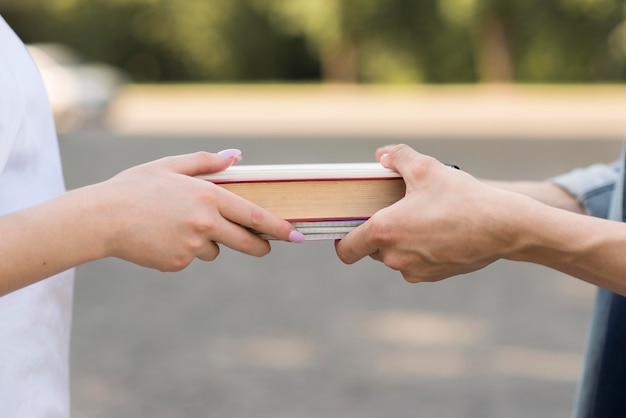 Studenti di primo piano che scambiano libro