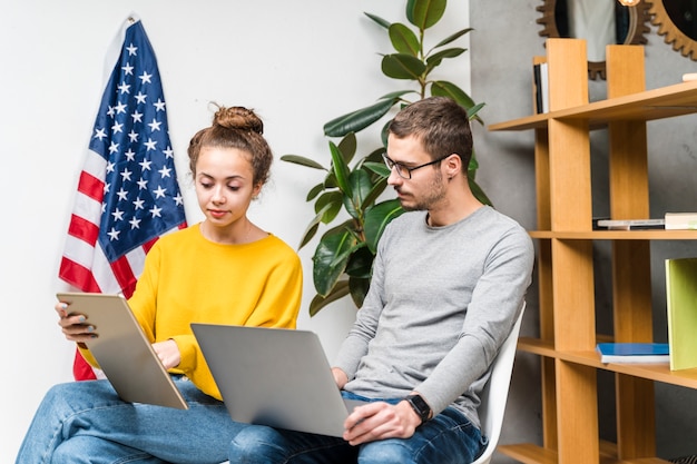 Studenti di tiro medio che utilizzano dispositivi all'interno