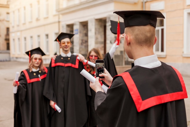 Studenti felici dell'angolo alto che prendono le foto