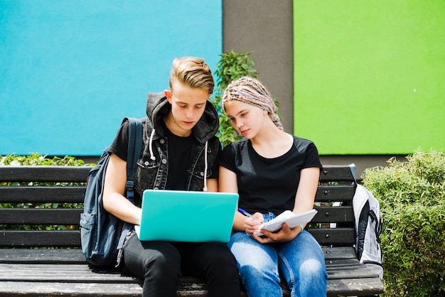 Studenti in posa su banco con computer portatile