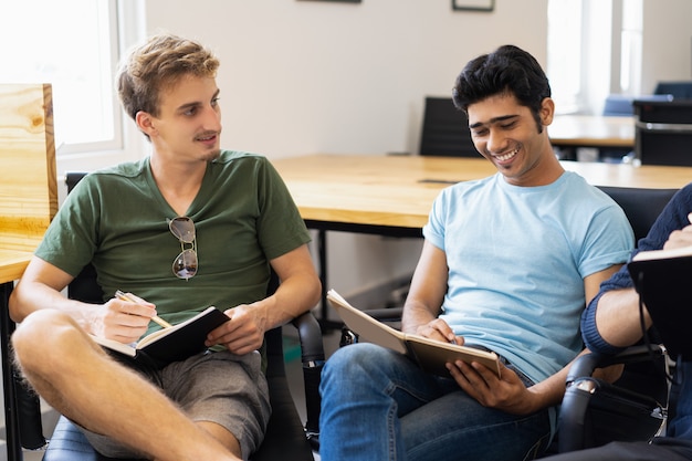 Studenti positivi che si siedono nel cerchio e che discutono progetto