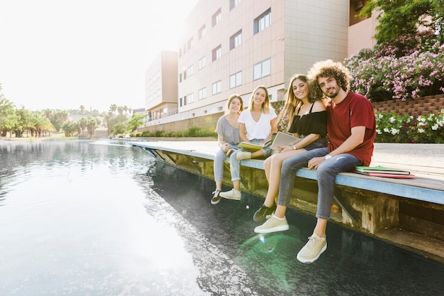 Studenti seduti nel campus con il lago