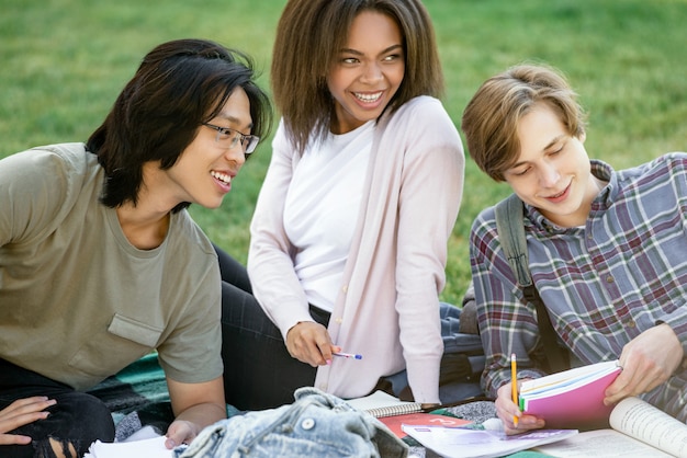 Studenti sorridenti che studiano all'aperto